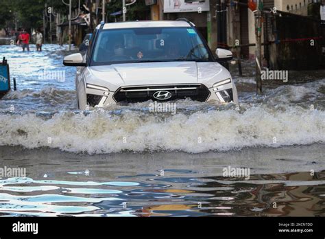 Commuters Wade Through A Water Logged Street Because Of Heavy Rain And