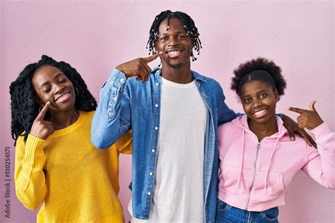 Group Of Three Young Black People Standing Together Over Pink