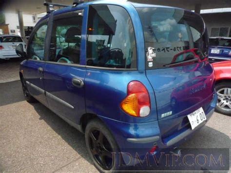 A Small Blue Car Parked In A Parking Lot