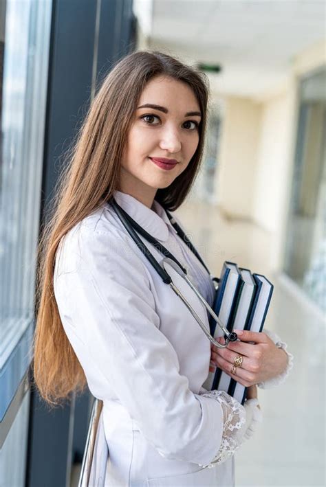 Young Nurse In Blue Uniform Posing In Hospital Corridor With