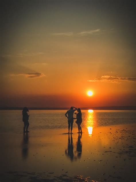 People Enjoying Sunset at a Sea Beach · Free Stock Photo