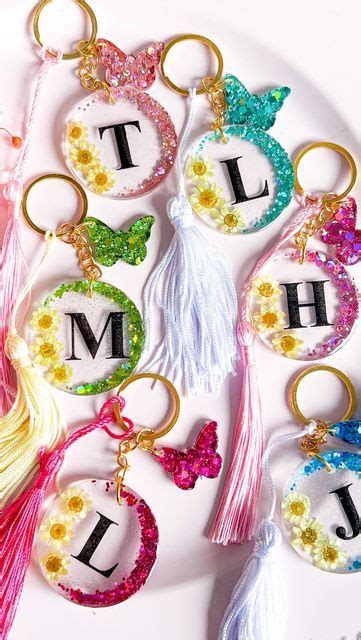 Several Key Chains With Letters And Tassels Attached To Each One On A Plate