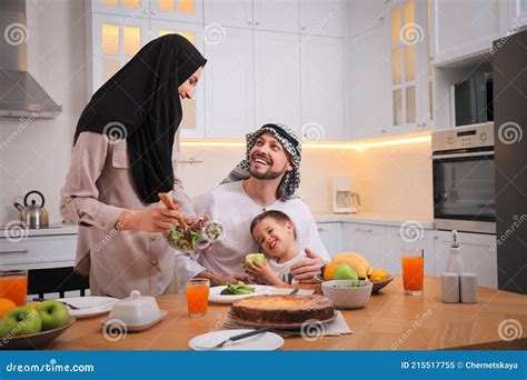 Familia Musulmana Feliz Comiendo Juntos En La Cocina Imagen De Archivo