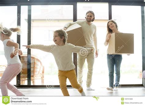 Enfants Jouant Dans La Nouvelle Maison Parents Tenant Des Boîtes Jour