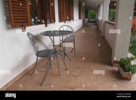 Dos Sillas Y Una Mesa En La Veranda De Una Larga Casa Campesina