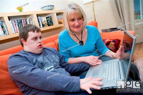 Mother And Teenage Son With Downs Syndrome Using A Laptop Computer