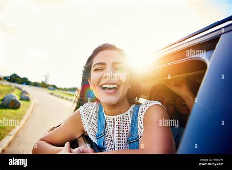 Pretty Woman In Speeding Car Smiles At Camera While Friends Laugh In