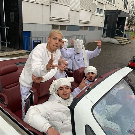 A Group Of People Riding In The Back Of A White Car On A City Street