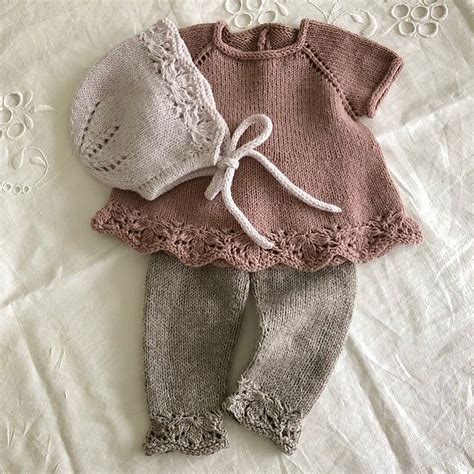 A Knitted Sweater And Pants Are Laying On A White Sheet With Crochet Lace