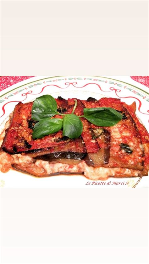 A White Plate Topped With Lasagna Covered In Sauce And Basil