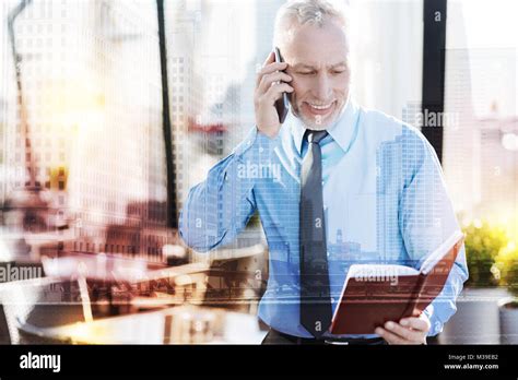 Confident Mature Businessman Reading Notes And Talking On The Phone