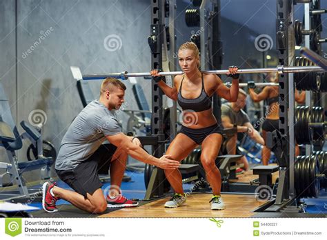 Homem E Mulher O Barbell Que Dobra Os Músculos No Gym Imagem de