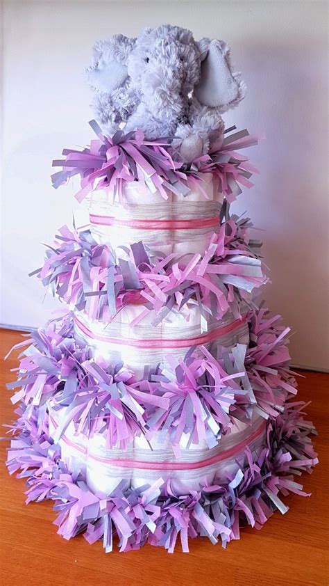 A Diaper Cake That Is Stacked On Top Of Each Other With Purple And