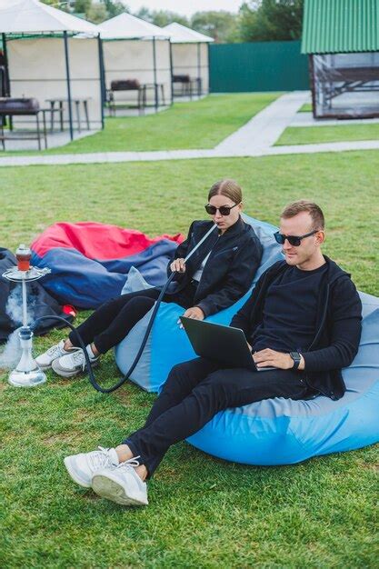 Um Jovem Casal Relaxa No Parque E Fuma Narguil Um Homem E Uma Mulher