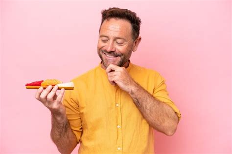 Hombre caucásico de mediana edad sosteniendo sashimi aislado de fondo