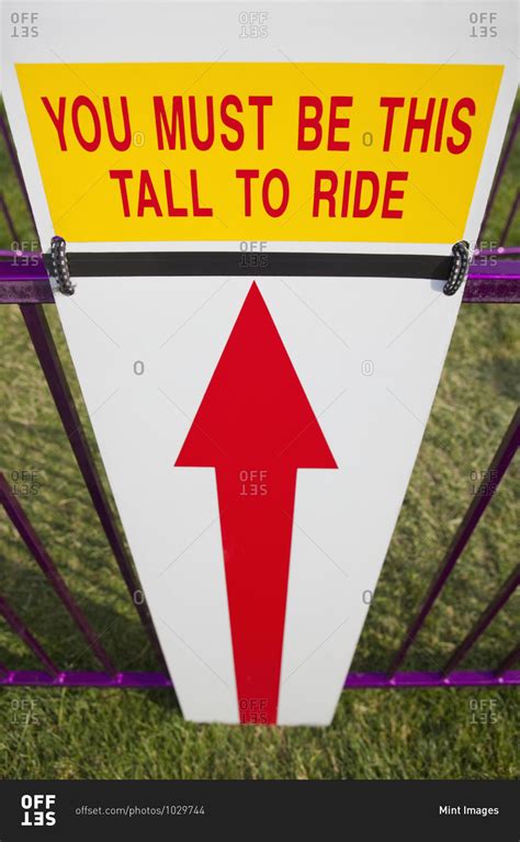 Height Requirement Sign In Front Of Amusement Park Ride stock photo - OFFSET