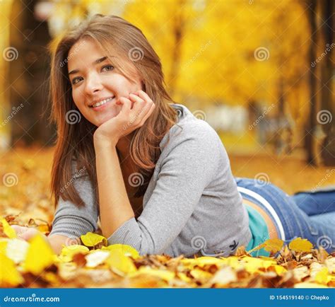 Young Woman Laying Down On The Ground In Autumn Park Beauty Girl In