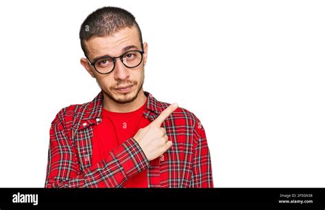 Hispanic Young Man Wearing Casual Clothes Pointing With Hand Finger To The Side Showing