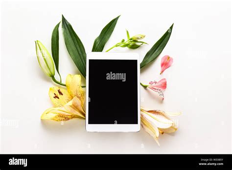 Tablet computer, flowers and leaves on white background Stock Photo - Alamy