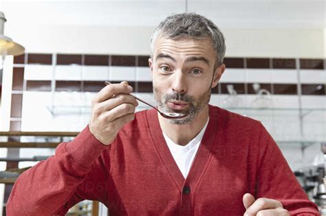 Germany Cologne Mature Man Holding Spoon Portrait Stock Photo