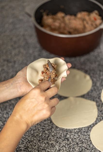 Manos De Mujer Llenando Una Empanada De Carne Argentina Foto Premium