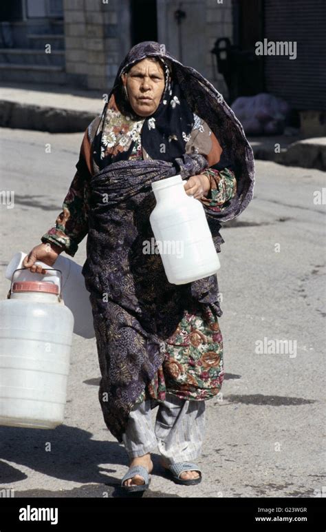 Elderly Iranian Woman Carrying Water Jugs Hi Res Stock Photography And