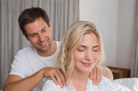 Hombre Sonriente Que Da Masajes A Los Hombros De La Mujer Foto Premium