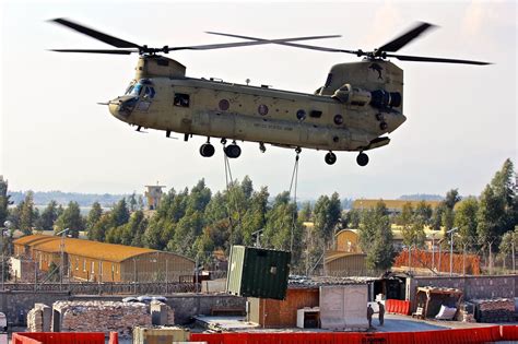 A Ch 47 Chinook Helicopter Lifts Off With A Shipping Container During