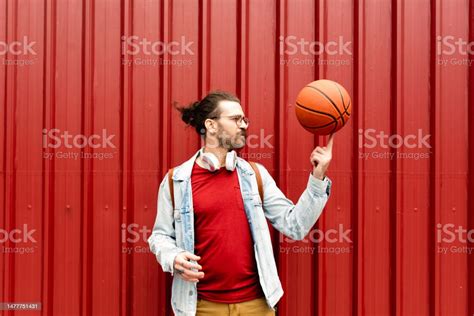 Portrait Of A Young Man Spinning Basketball Ball On His Finger Stock