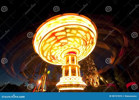 Colorful Chain Swing Carousel In Motion At Amusement Park At Night