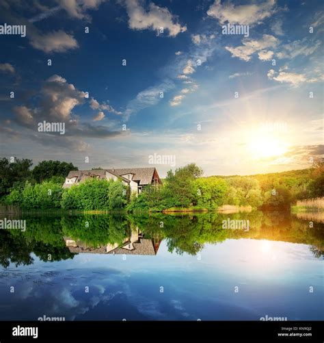 Sunset Over Village Near The Calm River Stock Photo Alamy