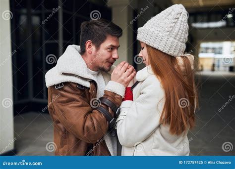 A Young Romantic Man Blowing To His Girl`s Palms Trying To Make Them