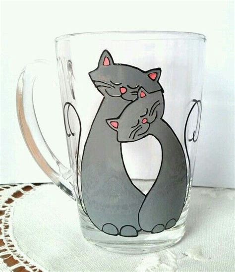 A Glass Mug With A Cat Design On It