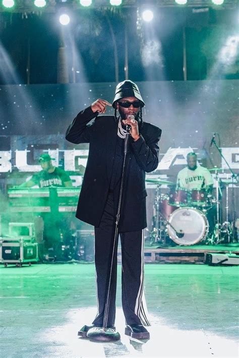 A Man Standing On Top Of A Stage Holding A Microphone In Front Of His Face