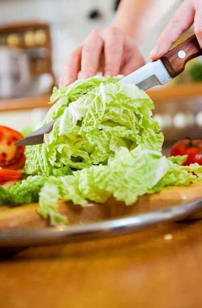 Premium Photo Womans Hands Cutting Lettuce Behind Fresh Vegetables