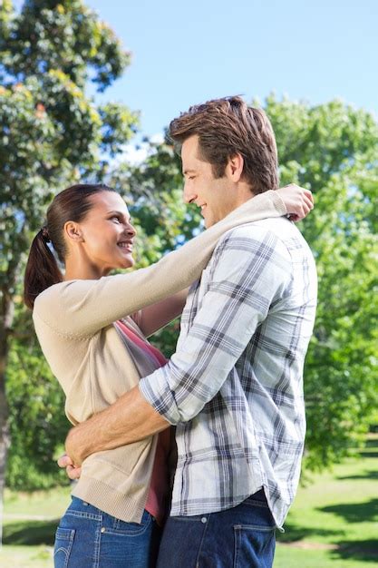 Feliz pareja abrazándose en el parque Foto Premium