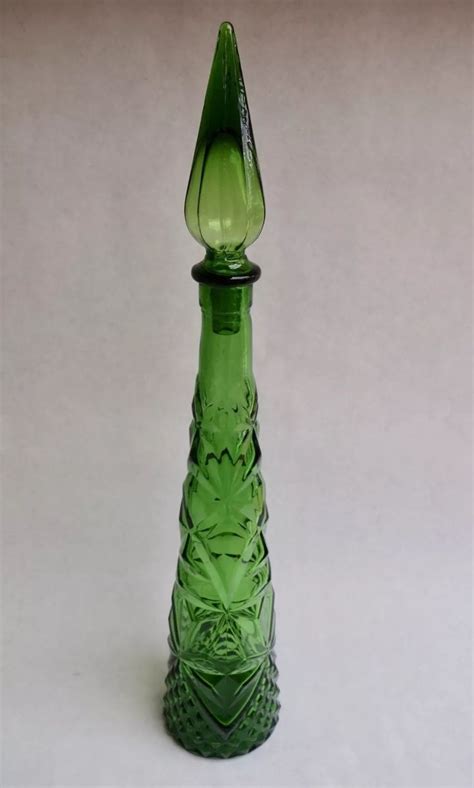 A Green Glass Vase Sitting On Top Of A Table