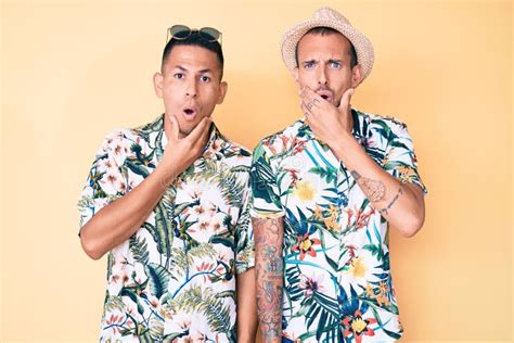 Joven Pareja Gay De Dos Hombres Con Sombrero De Verano Y Camisa Hawaiana Que Se Ven Fascinados