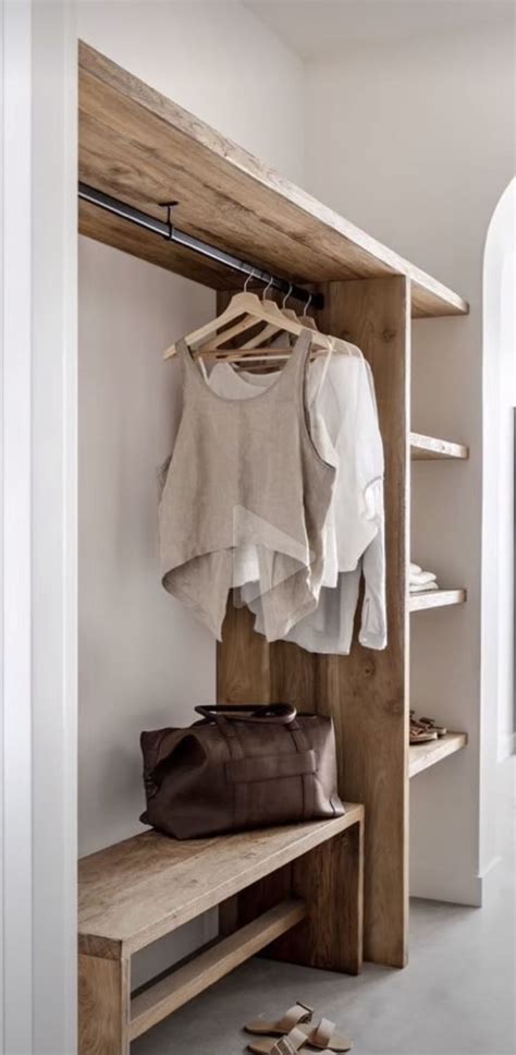 An Open Closet With Clothes And Shoes Hanging On The Wall Next To A