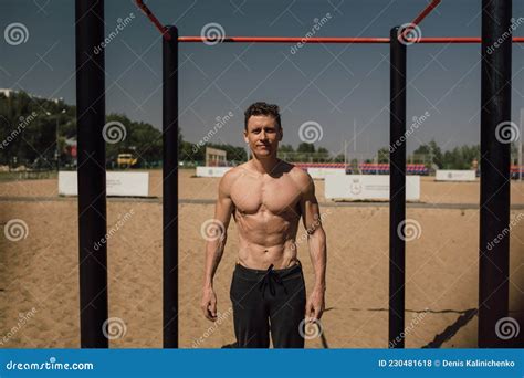 Handsome Young Man Doing Street Workout On The Beach In A Bright Summer