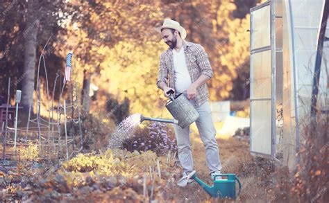 Premium Photo Man Farmer Watering A Vegetable Garden In The Evening