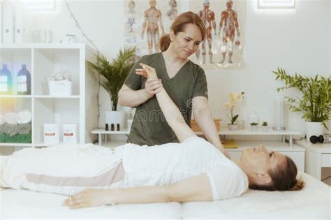 Happy Female Massage Therapist In Massage Cabinet Doing Checkup Stock