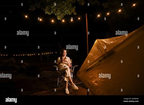 Beautiful Millennial Asian Female Relaxes Sipping Hot Cocoa Or Coffee While Looking At The