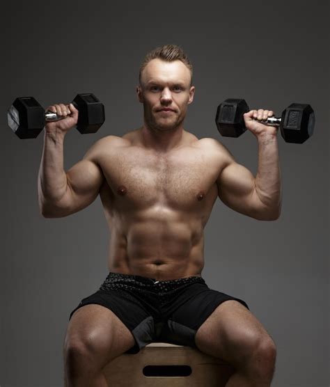 Free Photo Muscular Bodybuilder Guy Sitting On Chair And Doing