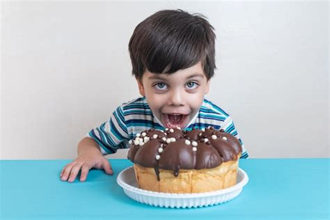 Lindo Adorable Chico En Estudio Comiendo Pastel De Chocolate Foto Gratis