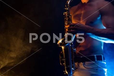 Muscular Man With Naked Torso Playing On Saxophone With Smoked Colorful Hi Res