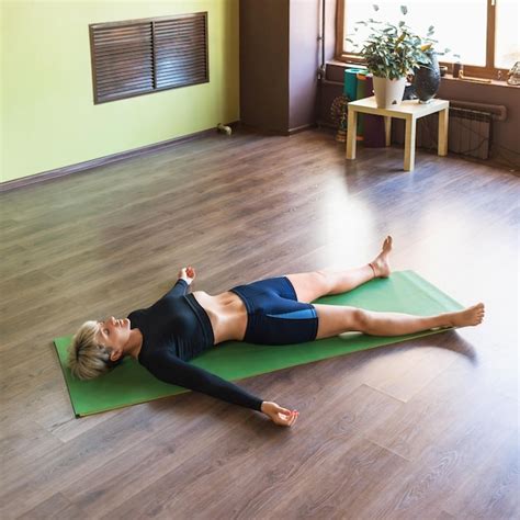 Premium Photo | Woman practicing yoga doing shavasana exercise with ...