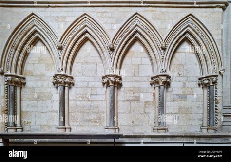 Decorative pointed gothic arches on the wall of the north aisle in the medieval cathedral at ...