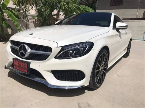 A White Mercedes Cla Parked In Front Of A House