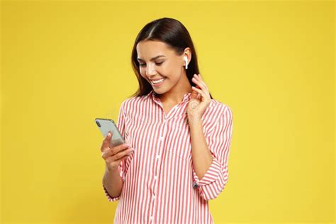 Happy Young Woman With Smartphone Listening To Music Through Wireless